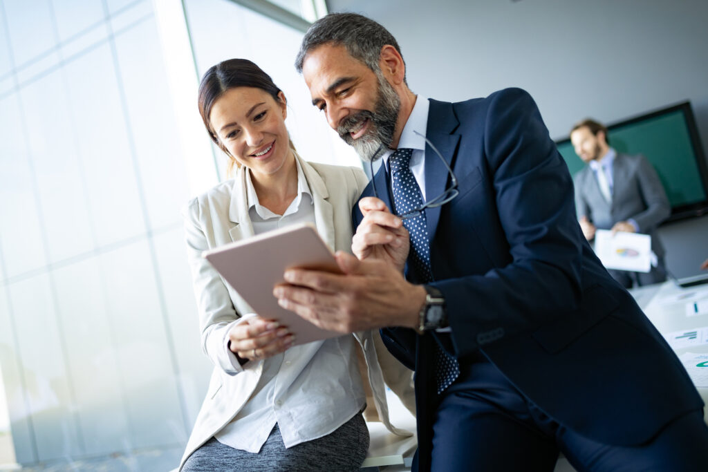happy business colleagues in modern office using tablet happy business colleagues in modern office using tablet